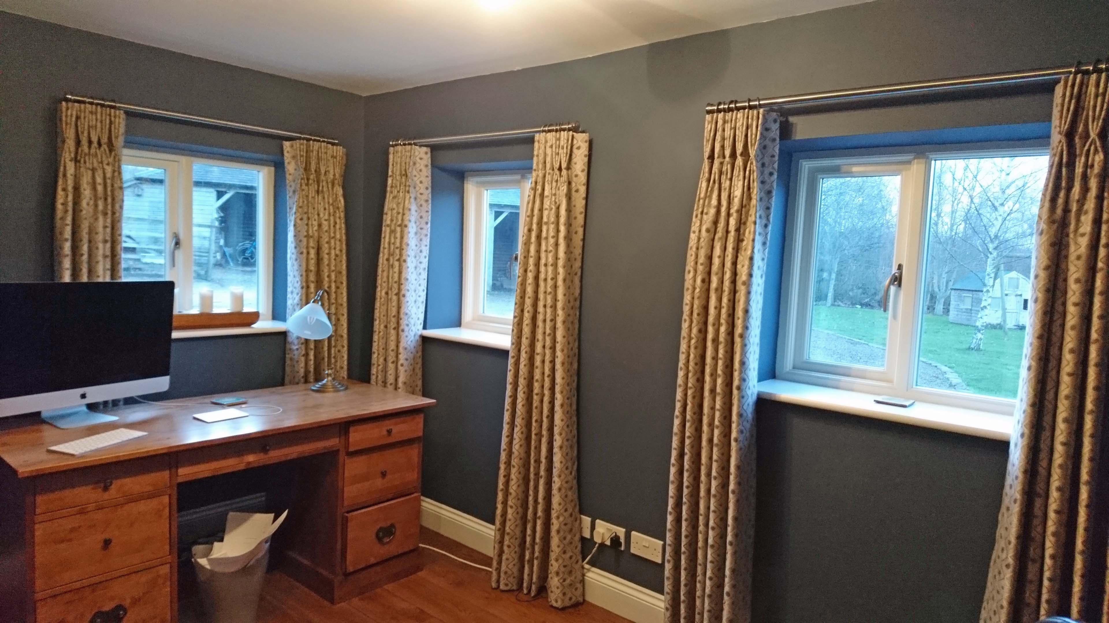 Three pairs of interlined curtains with triple pleats on a pole